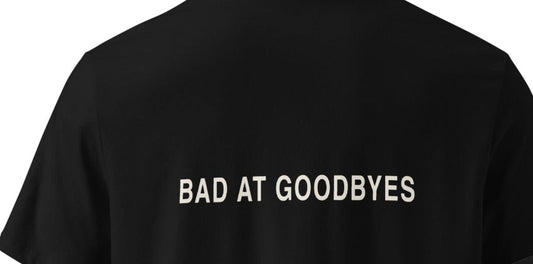 Κοντινή όψη του πίσω print BAD AT GOODBYES σε μαύρο unisex οργανικό T‑shirt UNEED