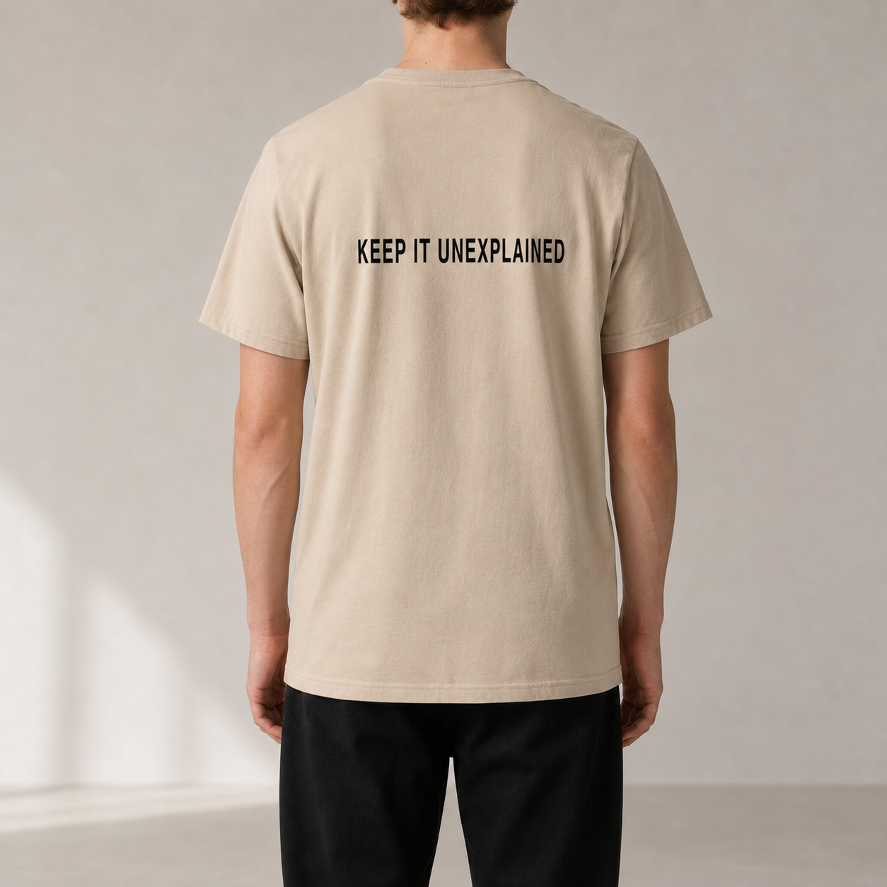 KEEP IT UNEXPLAINED Desert Dust organic statement T-shirt — realistic rear view on model